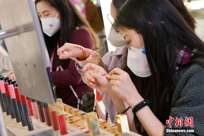 圖為女生正在體驗口紅產(chǎn)品。 殷立勤 攝