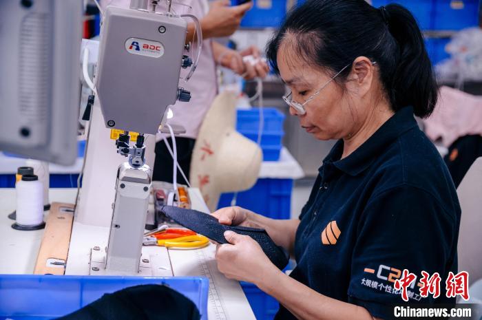 圖為員工在生產(chǎn)線工作?！±钅宪?攝